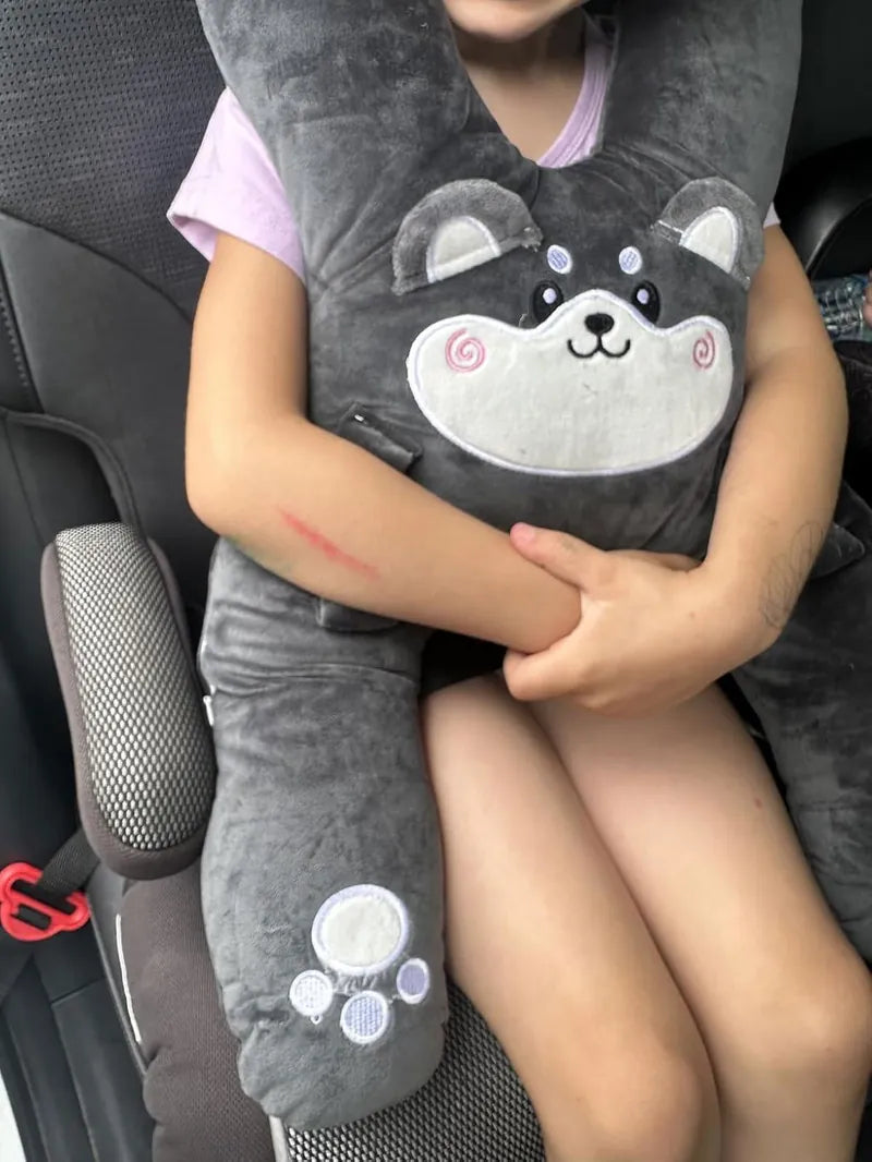 A girl in her booster seat hugging Niko the Husky, a customer photo