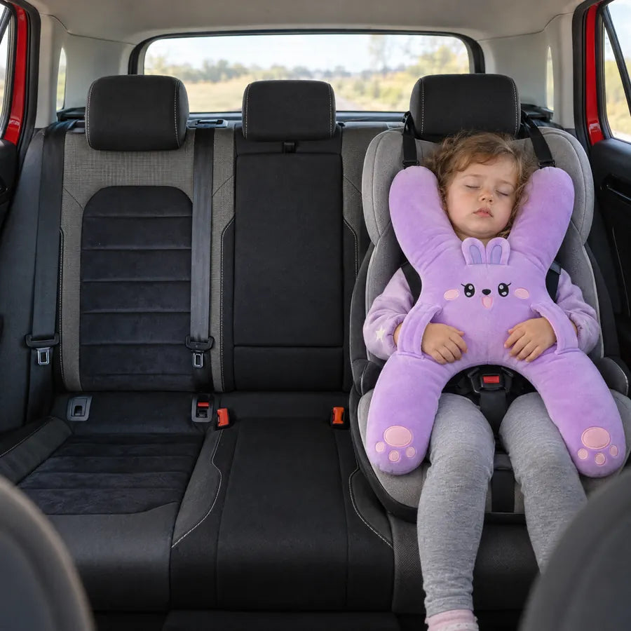 A toddler asleep in her car seat with Nina the Bunny