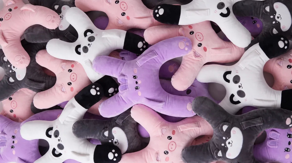 A pile of SnuggoWay kids travel pillows: Nina the bunny, Niko the husky, Ollie the piggy and Bao the panda